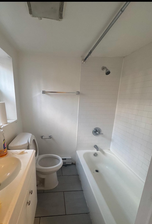 full bathroom featuring toilet, vanity, tile patterned floors, and tiled shower / bath