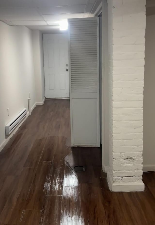 hallway featuring baseboard heating and dark hardwood / wood-style flooring