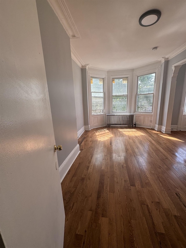 unfurnished room with dark hardwood / wood-style flooring, radiator heating unit, and ornamental molding