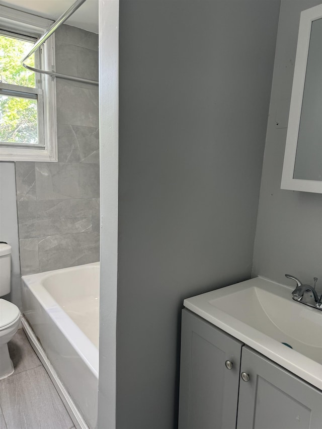 full bathroom featuring toilet, vanity, tile patterned floors, and tub / shower combination