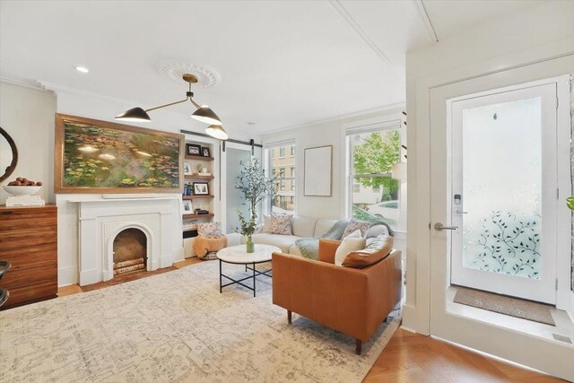 207 7th St, Hoboken, NJ 07030 - living area featuring ornamental molding, built in features, wood finished floors, and a fireplace with flush hearth