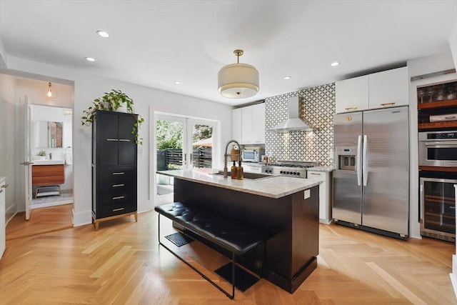207 7th St, Hoboken, NJ 07030 - kitchen featuring stainless steel appliances, wine cooler, wall chimney exhaust hood, white cabinetry, and recessed lighting