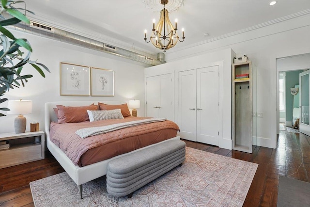 207 7th St, Hoboken, NJ 07030 - bedroom featuring multiple closets, a chandelier, dark wood-style flooring, ornamental molding, and baseboards
