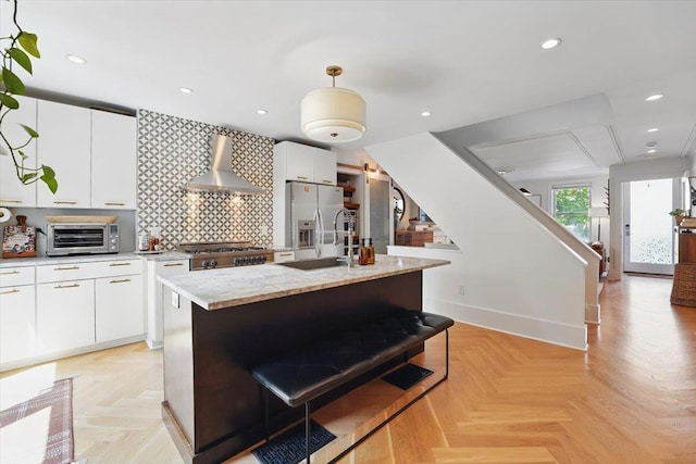 207 7th St, Hoboken, NJ 07030 - kitchen featuring wall chimney exhaust hood, a sink, stainless steel fridge with ice dispenser, an island with sink, and hanging light fixtures