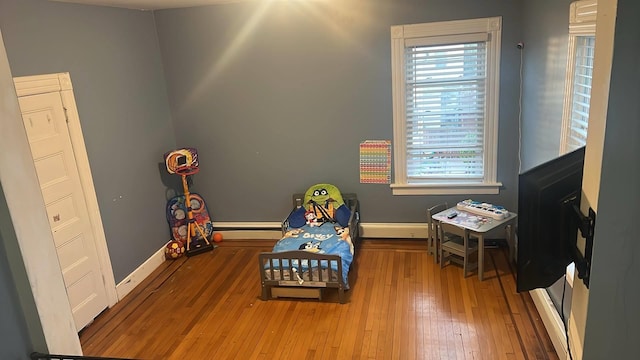 playroom with baseboards, plenty of natural light, and hardwood / wood-style flooring