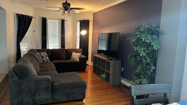 living area with crown molding, ceiling fan, a textured ceiling, and wood finished floors