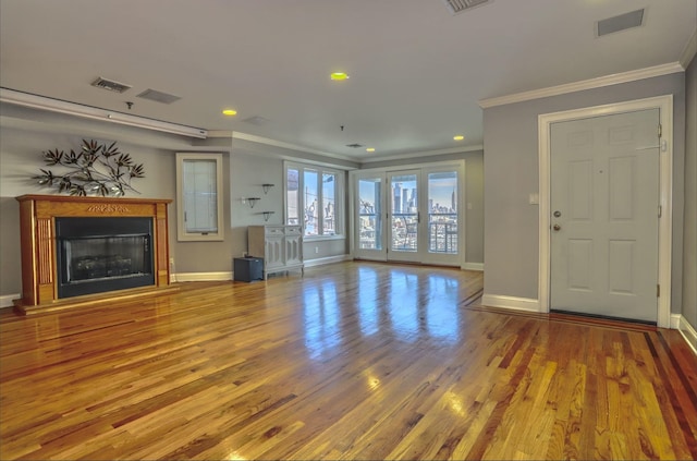 unfurnished living room featuring hardwood / wood-style floors and ornamental molding