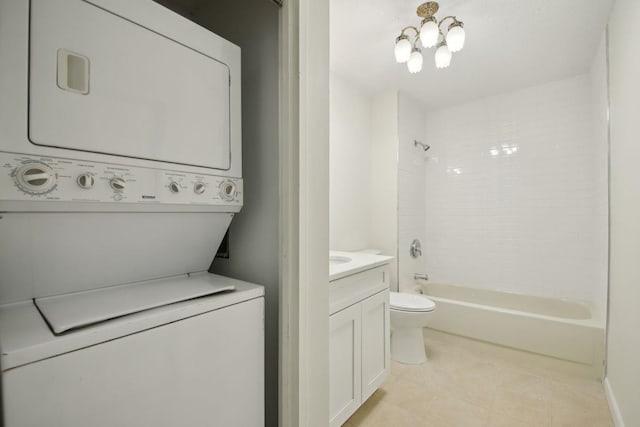 laundry room with stacked washer / drying machine, laundry area, and a notable chandelier