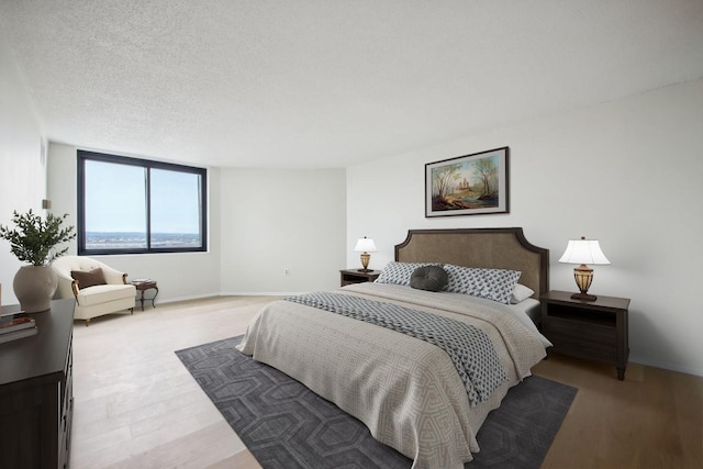 bedroom featuring a textured ceiling and wood finished floors