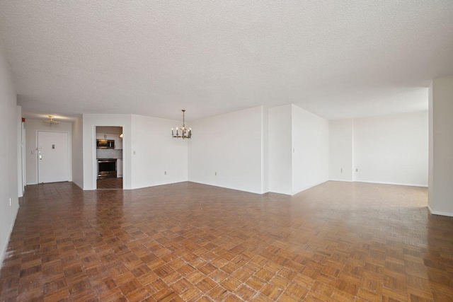 unfurnished living room with a textured ceiling, a fireplace, and a notable chandelier