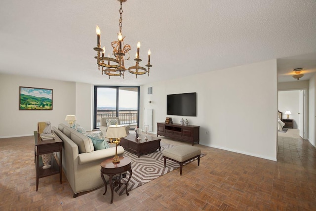 living room with an inviting chandelier, visible vents, baseboards, and a textured ceiling