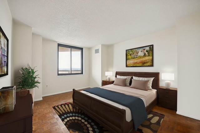 bedroom featuring a textured ceiling, visible vents, and baseboards