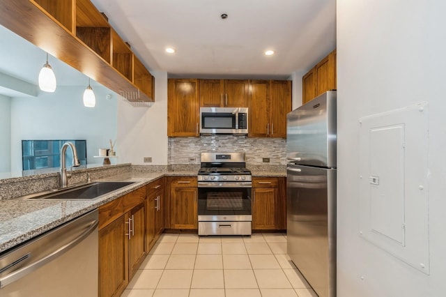 kitchen featuring sink, light tile patterned floors, appliances with stainless steel finishes, hanging light fixtures, and tasteful backsplash