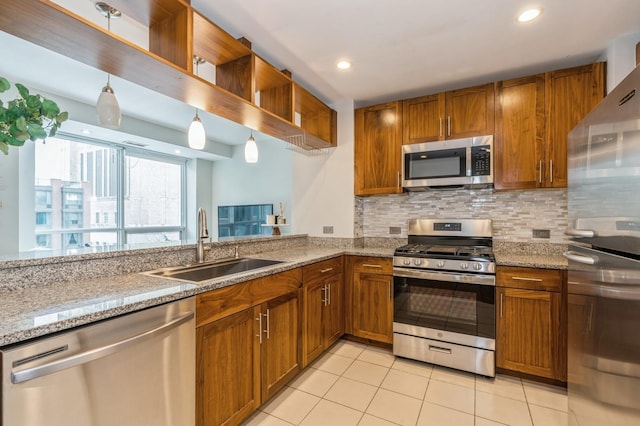 kitchen with stainless steel appliances, light stone countertops, sink, and decorative backsplash