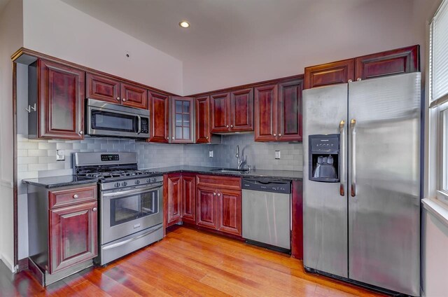 kitchen with sink, black fridge, tasteful backsplash, dark brown cabinets, and cooling unit