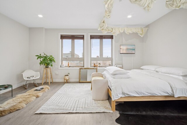bedroom featuring baseboards, recessed lighting, and wood finished floors
