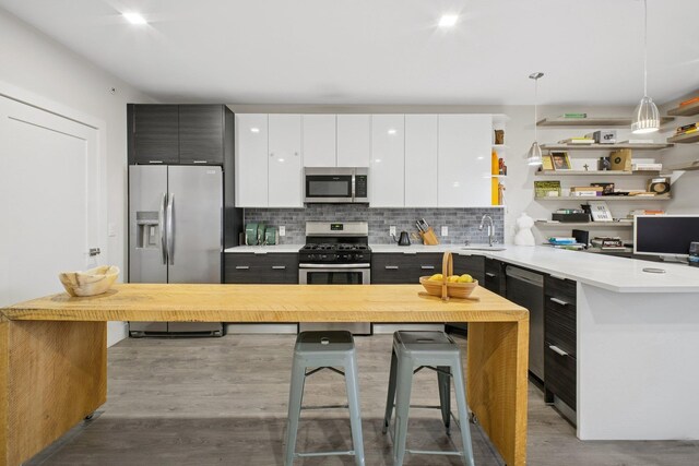 kitchen featuring light countertops, stainless steel appliances, white cabinetry, and wood finished floors