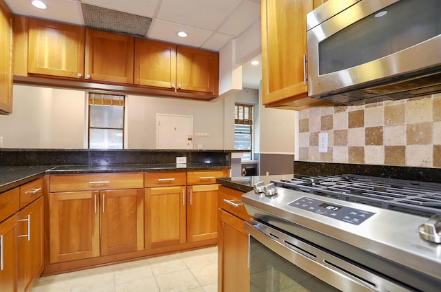 187 Wayne St Unit 208C, Jersey City, NJ 07302 - kitchen featuring stainless steel appliances, brown cabinets, decorative backsplash, light tile patterned flooring, and recessed lighting