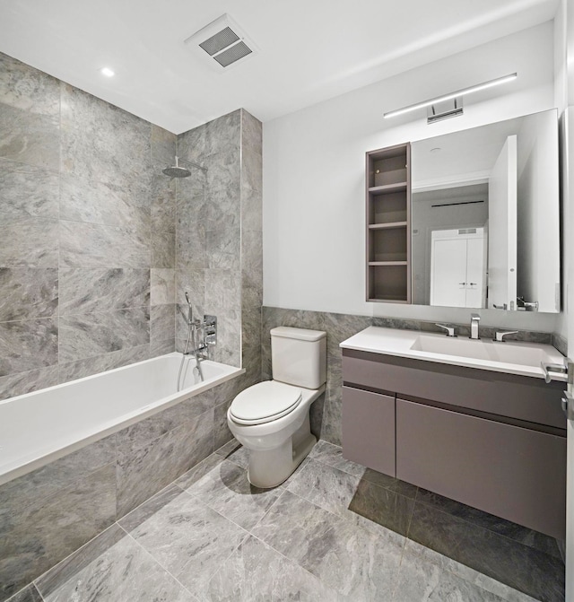 full bathroom with toilet, vanity, tile walls, and tiled shower / bath combo