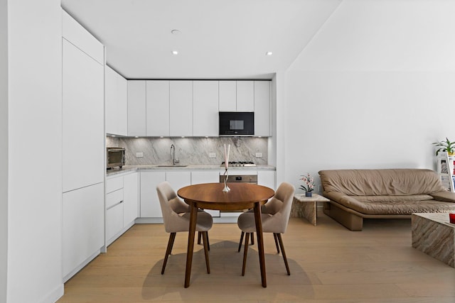 dining room featuring sink and light hardwood / wood-style floors