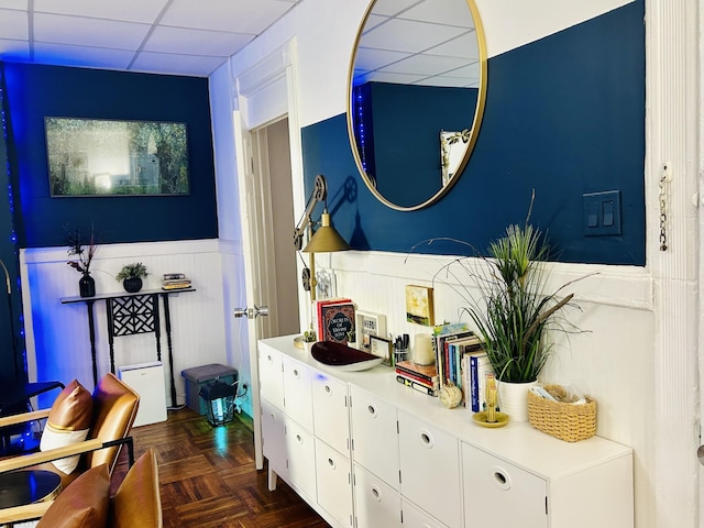 bathroom with a paneled ceiling, vanity, and a wainscoted wall