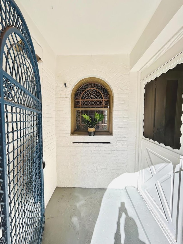 property entrance with brick siding and a porch