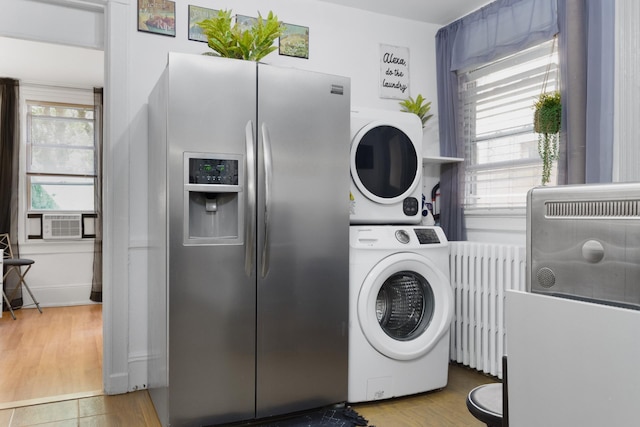 258 Montgomery St Unit 0, Jersey City, NJ 07302 - washroom with stacked washing machine and dryer, radiator heating unit, cooling unit, and wood finished floors