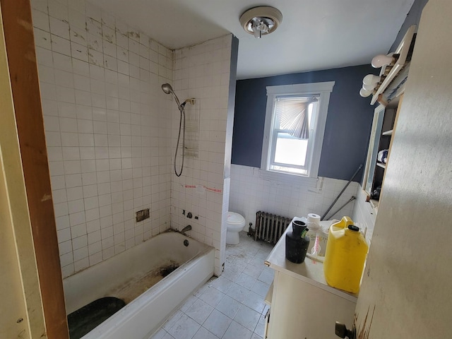 bathroom with wainscoting, toilet, tile patterned floors, radiator, and tile walls
