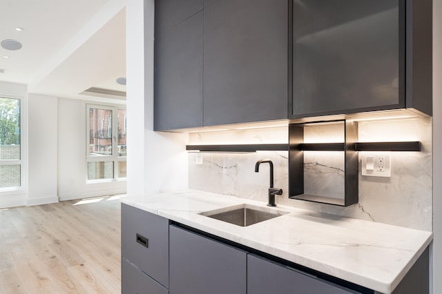 209 6th St Unit 1, Hoboken, NJ 07030 - kitchen with a sink, backsplash, light stone counters, light wood-style floors, and gray cabinets