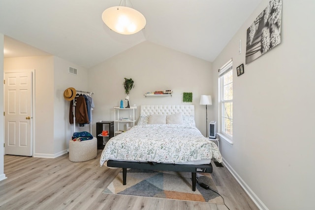 bedroom featuring light wood-type flooring and lofted ceiling