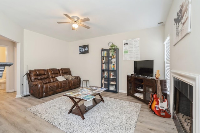 living room with light hardwood / wood-style floors and ceiling fan