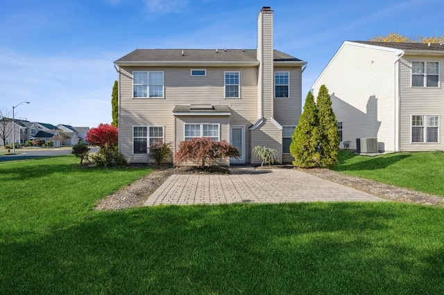 rear view of house with a patio, central AC, and a yard