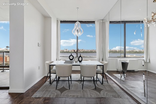 dining area featuring plenty of natural light, baseboards, a water view, and wood finished floors