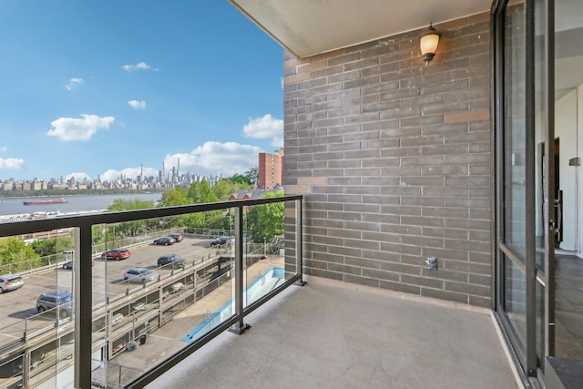 balcony featuring a water view and a city view