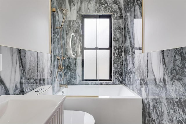 full bathroom featuring toilet, vanity, tile walls, and shower / bathtub combination