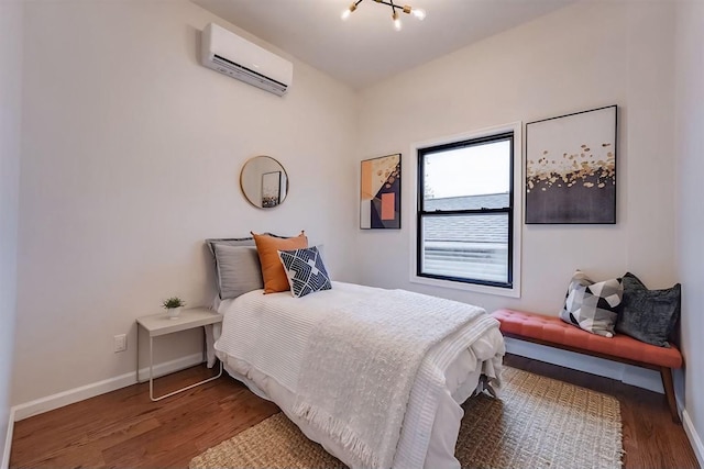 bedroom featuring a notable chandelier, dark hardwood / wood-style flooring, and a wall mounted air conditioner