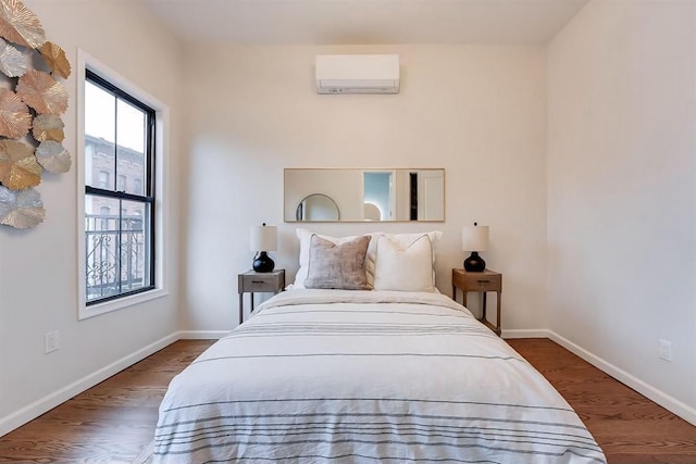 bedroom featuring an AC wall unit and hardwood / wood-style floors