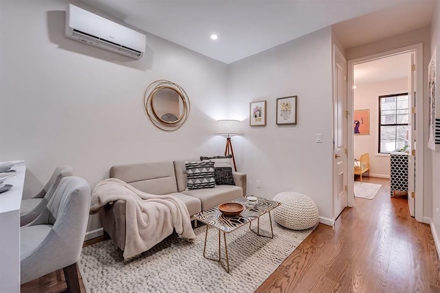 living room featuring a wall mounted AC and light wood-type flooring