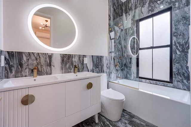 full bathroom featuring a chandelier, toilet, vanity, tile walls, and shower / bathing tub combination