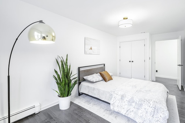 bedroom featuring a closet, a baseboard radiator, and dark hardwood / wood-style floors