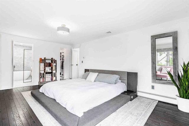 bedroom with dark hardwood / wood-style floors, ensuite bath, and baseboard heating