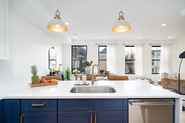 kitchen featuring a sink, blue cabinetry, open floor plan, light countertops, and stainless steel dishwasher