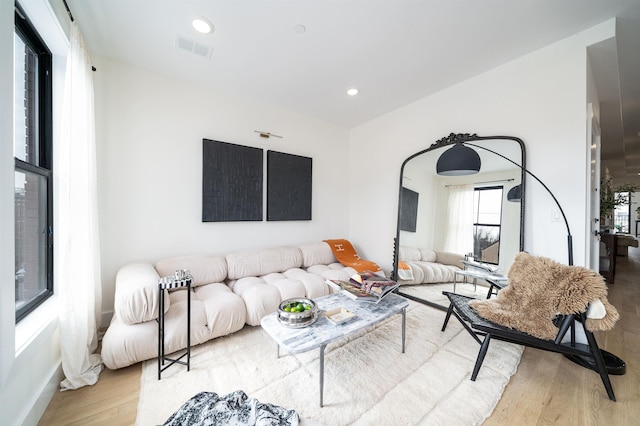 living room with recessed lighting, wood finished floors, and visible vents