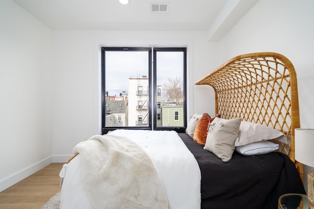 bedroom featuring recessed lighting, visible vents, baseboards, and wood finished floors