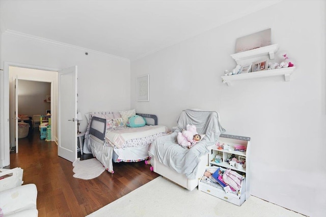 bedroom featuring ornamental molding and wood finished floors
