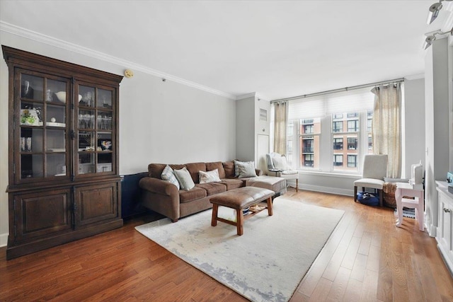 living area with ornamental molding and wood finished floors