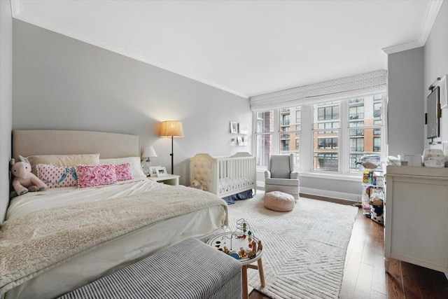 bedroom featuring crown molding, hardwood / wood-style flooring, and baseboards