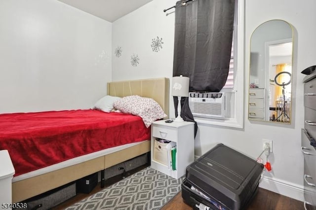 bedroom with cooling unit and dark wood-type flooring