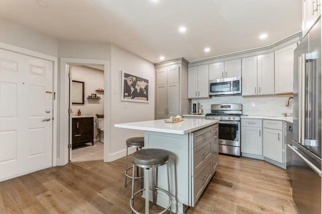 801 Willow Ave Unit 3R, Hoboken, NJ 07030 - kitchen featuring appliances with stainless steel finishes, gray cabinets, a kitchen bar, a kitchen island, and light countertops