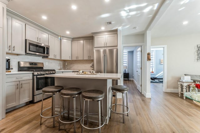 801 Willow Ave Unit 3R, Hoboken, NJ 07030 - kitchen with stainless steel appliances, gray cabinetry, tasteful backsplash, a center island with sink, and recessed lighting